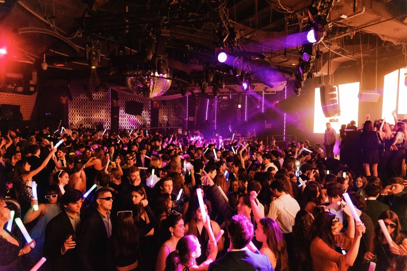 The crowd erupts with glow sticks and foam batons during the hora loca